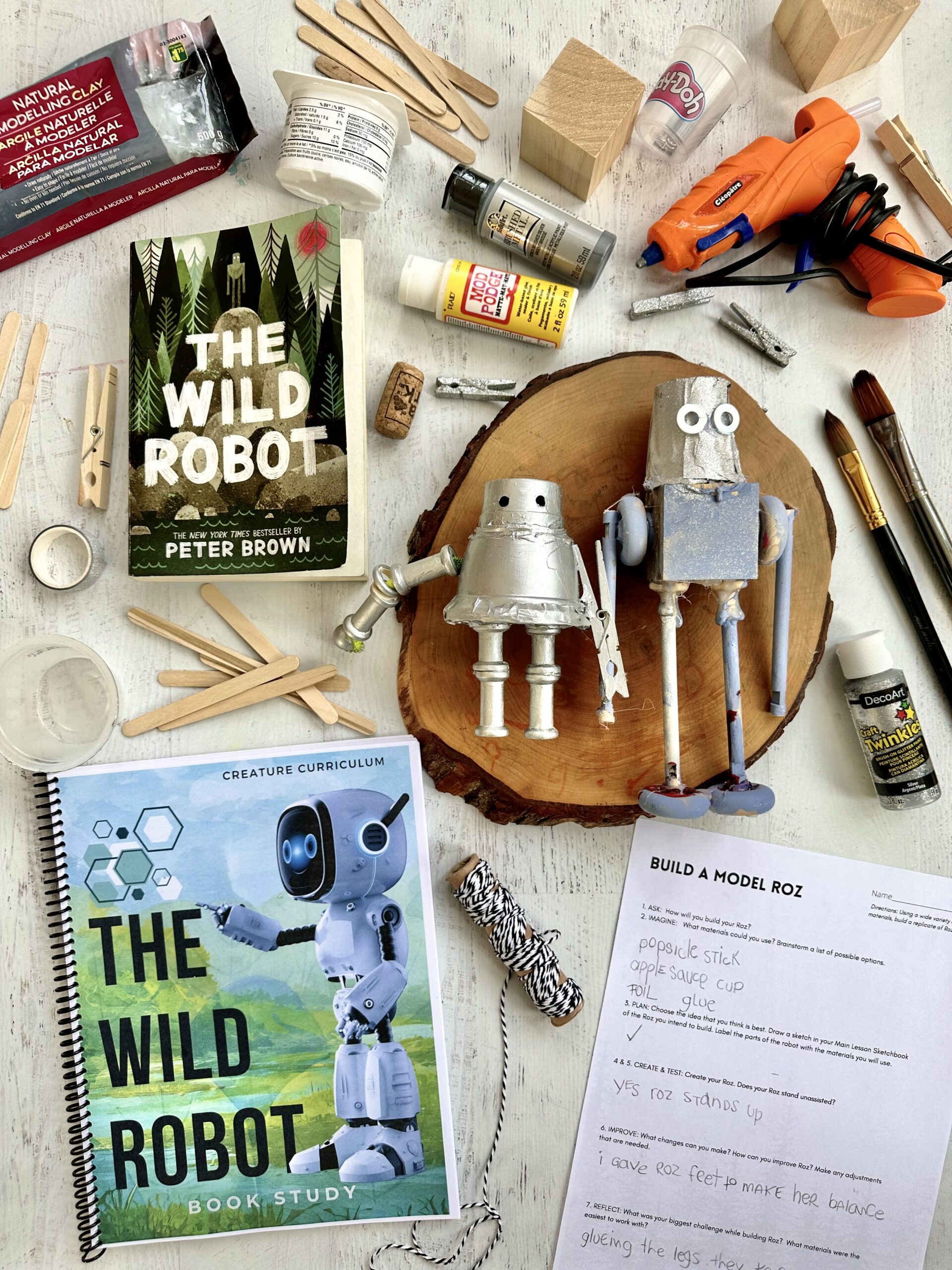 A table topped with books and other art supplies.